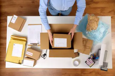 Illustration showing a person sitting at a desk, surrounded by papers and a laptop, engaged in writing a grant proposal, symbolizing the focused effort and attention to detail required for successful grant proposal writing.